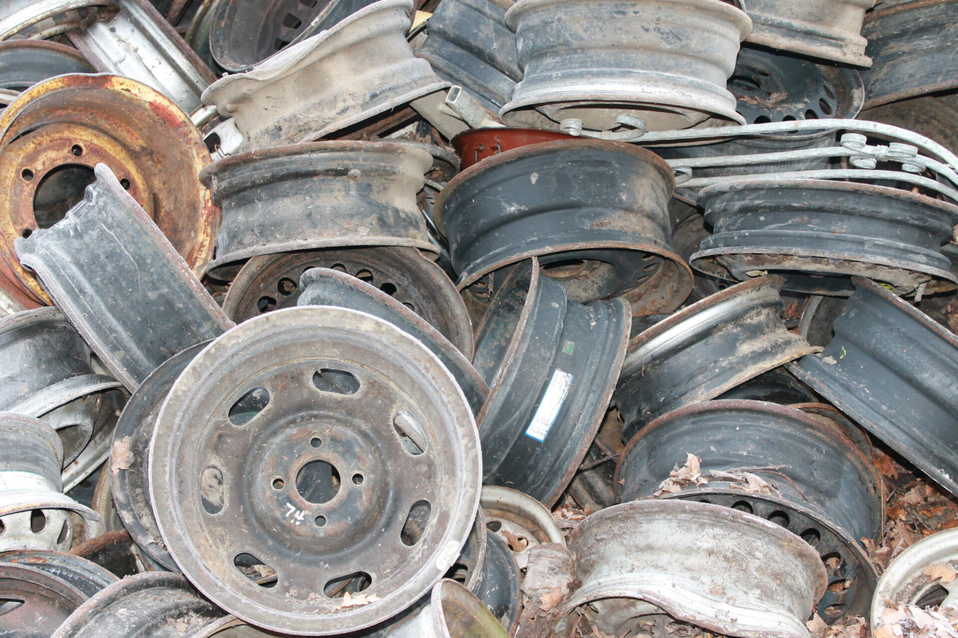 Stapel aus gebrauchten Stahl- und Aluminiumfelgen auf dem Schrottplatz von Jungkurth Recycling – angelieferte Altmetalle zur Verwertung und Wiederaufbereitung.